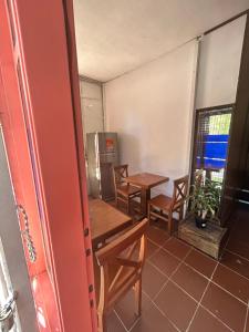 科洛尼亚-德尔萨克拉门托Hostel Parece Mentira的配有2张桌子和椅子以及冰箱的房间