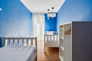 塞图巴尔Wonder Blue的一间拥有蓝色墙壁的卧室、一张床和一张婴儿床