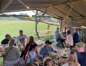 GraffhamBeautiful Yurt with stunning South Downs views的一群人坐在帐篷下的桌子上