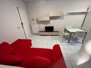 布雷西亚Appartamento Civico 23的客厅配有红色的沙发和桌子