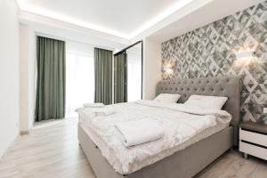 基希讷乌豪华公寓的一间卧室配有一张大床和灰色床头板