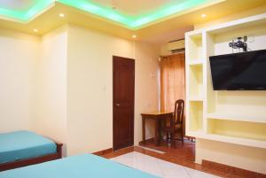 瓜亚基尔Hostal Galápagos - Guayaquil的客房设有1张床、1台电视和1张桌子。