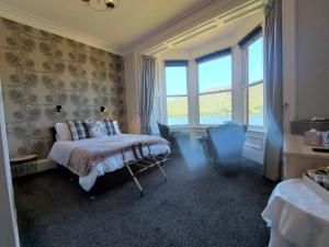威廉堡拉瑞斯通旅馆的一间卧室配有一张床、一把椅子和窗户。