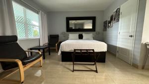 沃思湖白马汽车旅馆 的一间卧室配有一张床、一把椅子和一把椅子