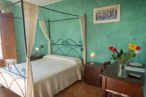 Petrignano巴巴罗萨B&B别墅酒店的一间卧室,配有一张床和花瓶