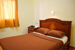 瓜亚基尔Hostal Galápagos - Guayaquil的卧室内的一张带木制床头板的床