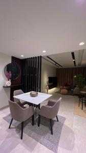 马斯喀特Luxury apartment in Muscat Hills的一间带桌椅的用餐室和一间客厅