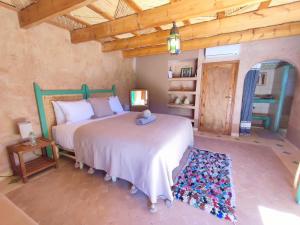 阿伊特本哈杜Maison d'hôtes Tigminou - Adults Only的一间卧室设有两张床和木制天花板