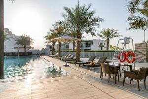 迪拜3 Bedroom townhouse furnished的游泳池旁设有桌椅