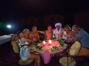El GoueraBivouac Le charme d'Aladdin的一群人坐在桌子旁