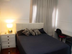 贝洛奥里藏特Apartamento Gutierrez 1的一间卧室配有一张床和一张带台灯的书桌