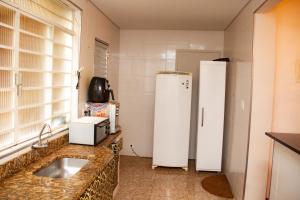 贝洛奥里藏特Apartamento Gutierrez 1的厨房配有水槽和白色冰箱