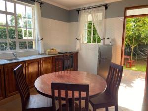阿鲁沙Daria Apartment -Burka -3 minutes from Arusha Airport的厨房配有桌椅和冰箱。