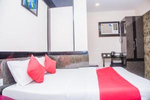 阿加尔塔拉OYO Hotel Executive Inn的卧室配有带红色枕头的大型白色床