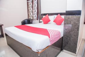 阿加尔塔拉OYO Hotel Executive Inn的一间卧室配有红色枕头的床