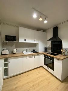 圣皮耶尔代科尔普Appartement cosy près de la gare avec parking的厨房配有白色橱柜和炉灶烤箱。