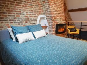 瓦朗西纳Calme/ Confortable / Esthétique / Centre-ville的一间卧室设有一张床和砖墙