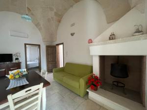 佩兹迪格雷科L'Antico Camino的客厅设有绿色沙发和壁炉