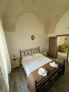 佩兹迪格雷科L'Antico Camino的一间卧室配有一张带白色床单的大床
