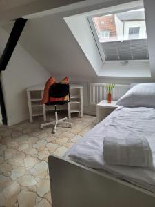 哈根Stadthaus nahe Fußgängerzone的一间卧室配有一张床、一张书桌和一个窗户。