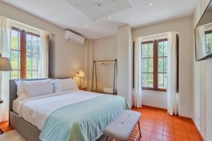 塞图巴尔Villa Casal Assis的一间卧室设有一张大床和两个窗户。