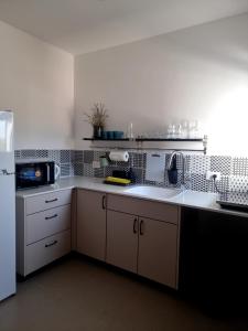 Ma‘yan Barukhכחול ולבן的厨房配有白色的柜台和白色的冰箱。