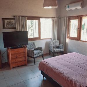 卢汉德库约El descanso, zona de bodegas的一间卧室配有一张床和一台平面电视