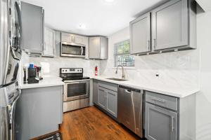 休斯顿Stunning & Vibrant APT 7 Min From TX Med Center的厨房配有不锈钢用具和白色橱柜