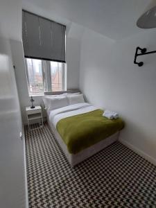 曼彻斯特bankwellstreet的小卧室配有一张带绿毯的床