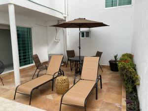 博卡德尔里奥Casa boka con vista al mar y alberca的庭院配有桌椅和遮阳伞。