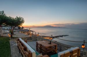 基普塞利Omega Estate Resorts的海面上的日落,一张桌子和长椅