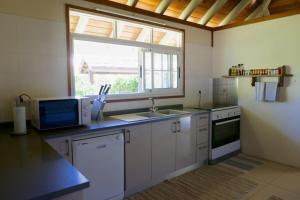 OtumaiVilla Ohana - Deluxe Villa w Private Beachfront的厨房设有水槽和窗户。
