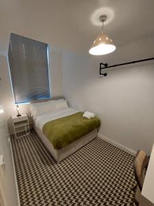 曼彻斯特bankwellstreet的一间卧室配有一张带绿毯的床