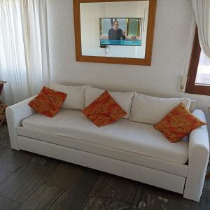 埃斯特角城Frente a playa brava的客厅配有带四个枕头的白色沙发