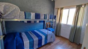 且乌塔Cabañas Laureano AJ的一间卧室配有一张蓝色和白色条纹的双层床