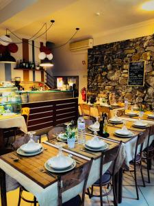 科维良阿布里格达埃斯特雷拉住宿加早餐旅馆的一间带桌椅和石墙的用餐室