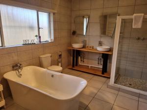 阿尔伯顿Sha-Mani Guesthouse & Conference Venue的带浴缸、卫生间和淋浴的浴室。