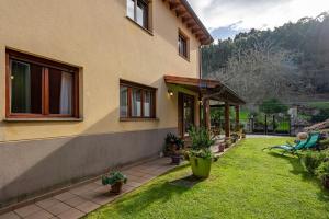 纳韦斯Llanes Asturias的一座有绿色草和植物的院子的房子