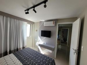 伊泰帕瓦Vila Piemont Itaipava的一间卧室配有一张床和一台平面电视