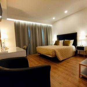 圣佩德罗温泉Casa do Rio的一间卧室配有一张床、一张桌子和一张沙发