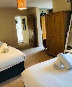 沃顿安德埃奇加农缪斯旅馆的一间卧室设有两张床和木制橱柜