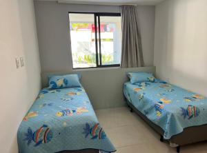 伊塔齐米林Itacimirim pé na areia 2Q的一间卧室设有两张床和窗户。