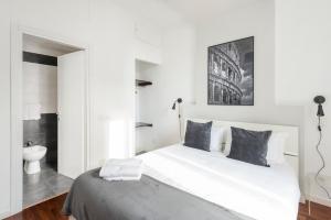 罗马白色特米尼公寓的白色的卧室设有一张大床和一间浴室。