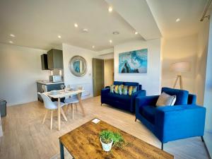 NailseaServiced Apartments Nailsea的客厅配有蓝色的沙发和桌子