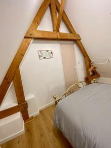 Coupelle-VieilleLe Clos des deux chênes的卧室设有白色的床和木梁。
