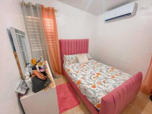 Villa IsabelaAcogedora casa de 2 habitaciones的一间小卧室,配有粉红色的床和一张桌子