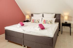 利普施塔特HAMA Design Homes的一间卧室配有一张大床,上面有粉红色的拖鞋