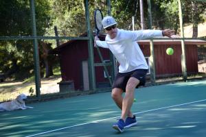 卡梅尔瓦利The Camp at Carmel Valley的男子在网球上挥舞网球拍