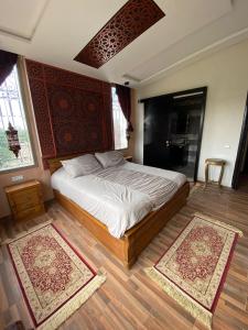 本苏莱曼Dar Ghita en campagne的卧室配有一张床,地板上铺有2个地毯。
