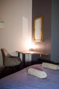 里加希娜蒙莎莉背包客旅馆的一间卧室配有一张床、一张书桌和一面镜子